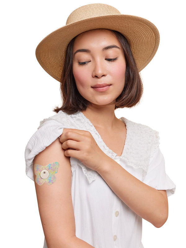 FreeStyle Libre 3 butterfly shape patch worn on a woman’s arm, with breathable adhesive fabric for sensor support