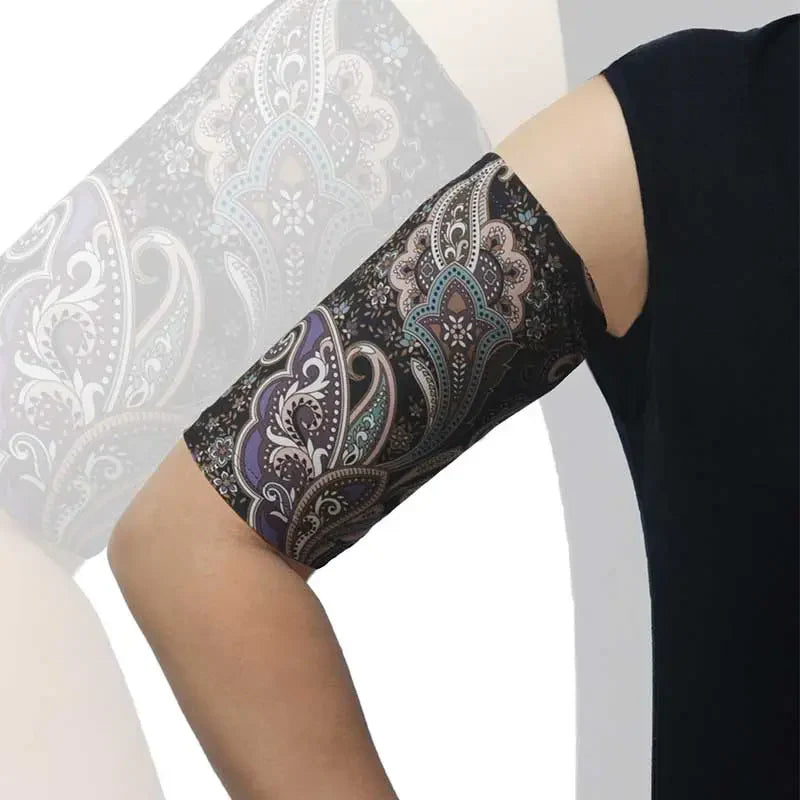 PICC line arm sleeve with a black background and colorful paisley pattern, worn on an arm for comfortable, protective daily use. Image