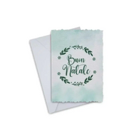 Elegant Christmas greeting card with "Buon Natale" inscription, featuring a festive wreath design, accompanied by an envelope.