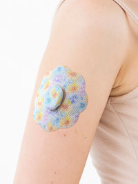 Dexcom G7 adhesive patch, cookie shape, on the arm, close-up
