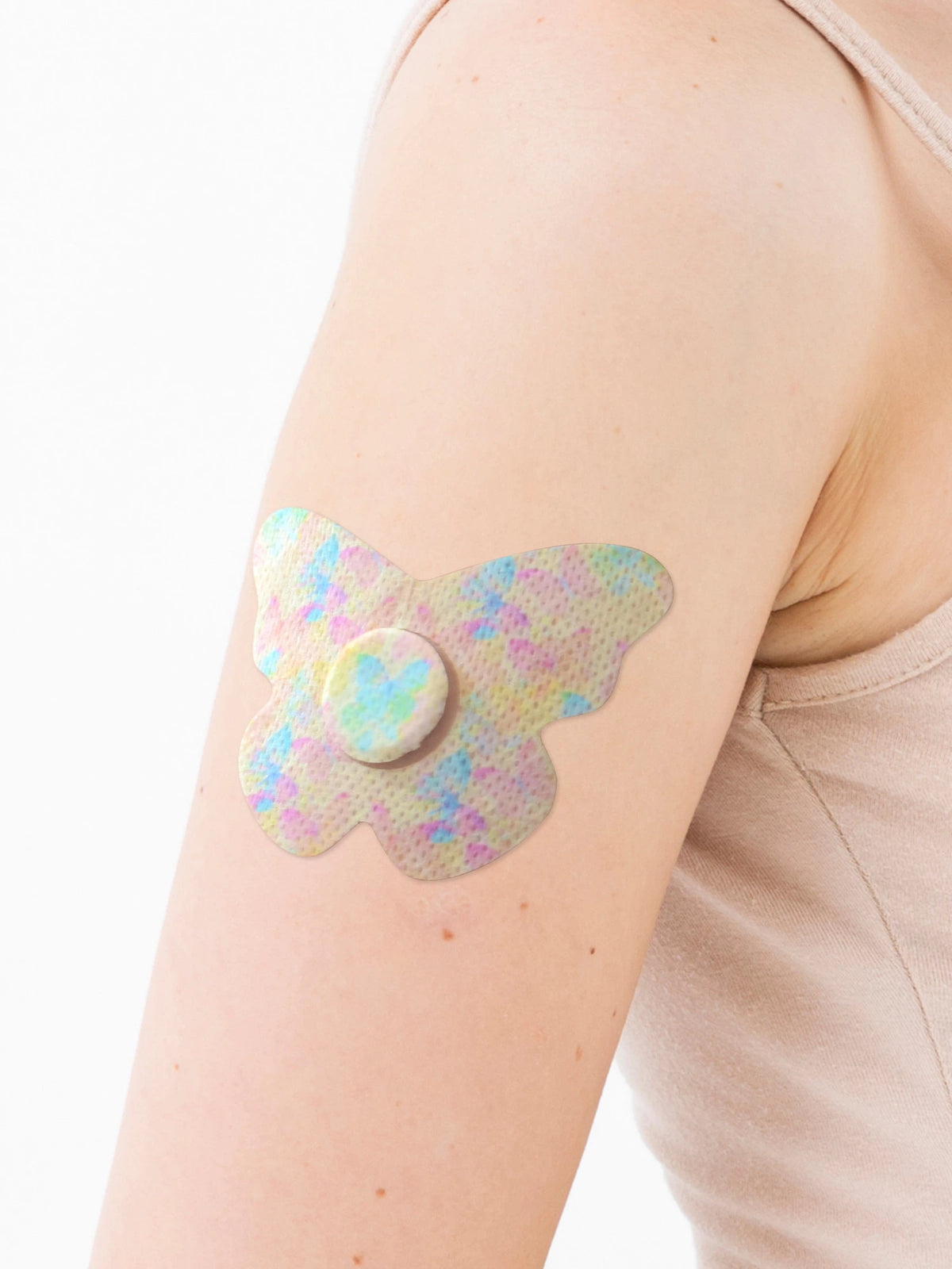 FreeStyle Libre 3 butterfly shape patch close-up on arm, showing breathable adhesive support around the sensor