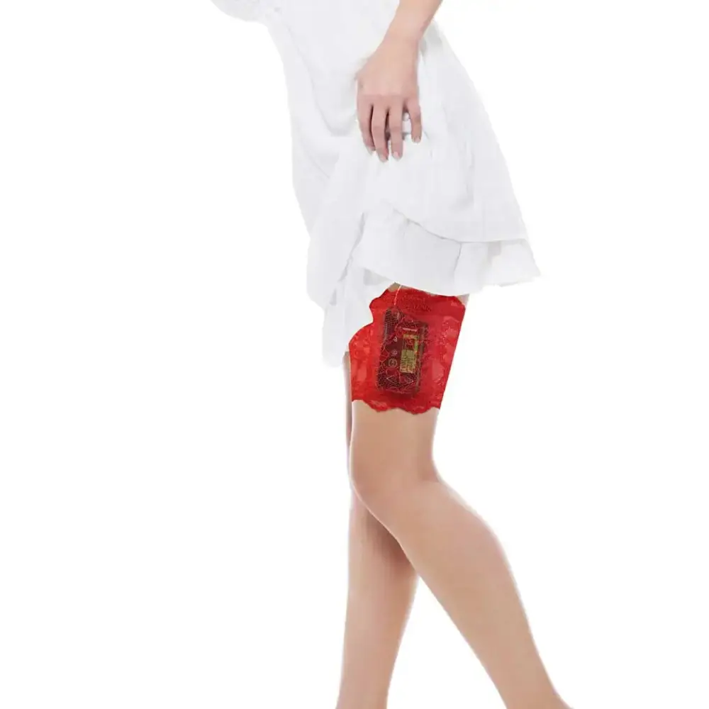 Red lace garter leg band securely holding an insulin pump, worn under a white dress