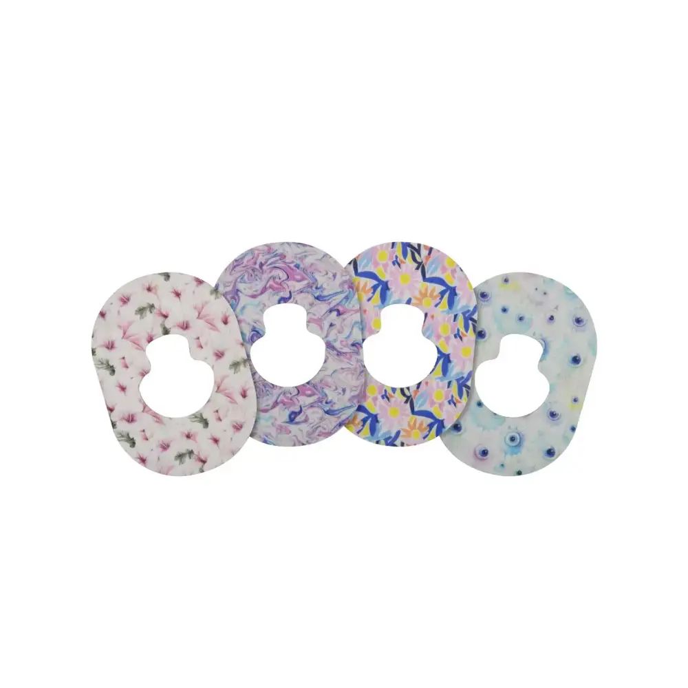 Four Guardian Enlite adhesive patches featuring spring patterns for secure hold