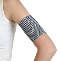 Trendy CGM armband for diabetes with black and white pattern, worn on upper arm.